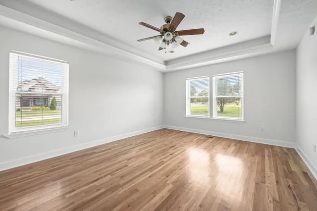 an empty room with a window and a ceiling fan