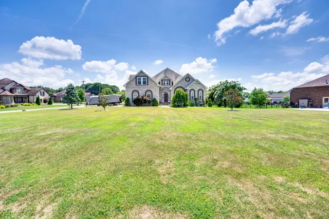 a front view of a house with a big yard