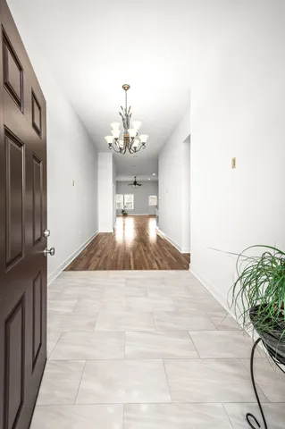 an empty room with wooden floor fireplace and windows