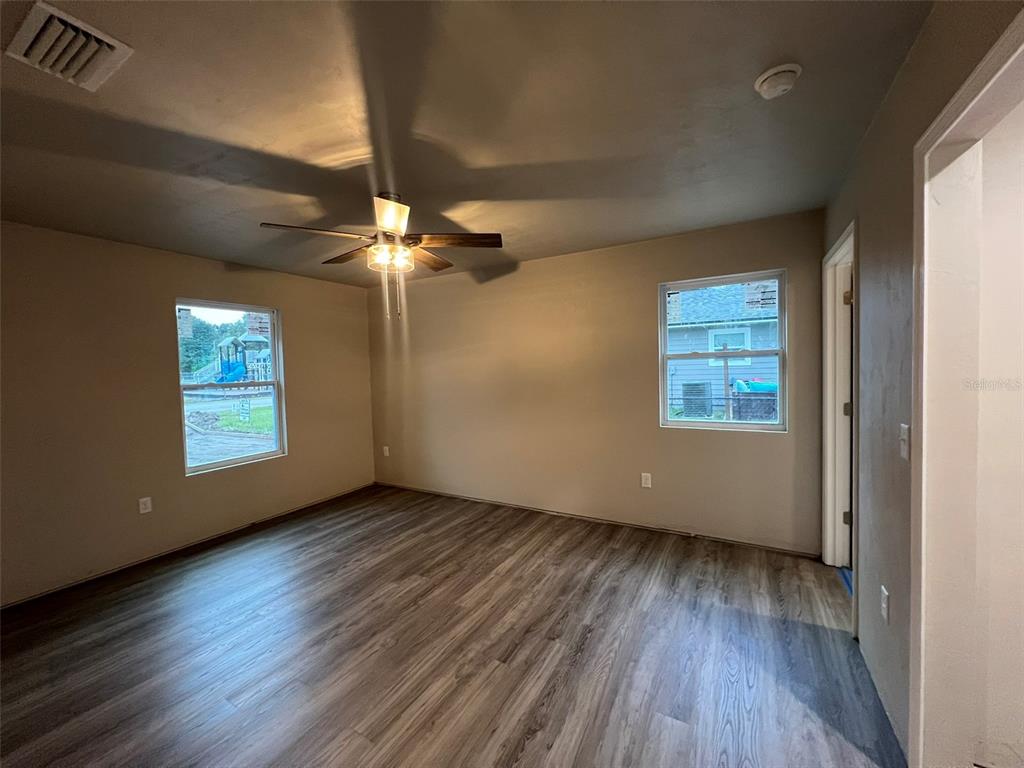 24948 Northwest 187th Avenue High Springs, FL 32643 - Photo 7 of 14 an empty room with wooden floor chandelier fan and windows