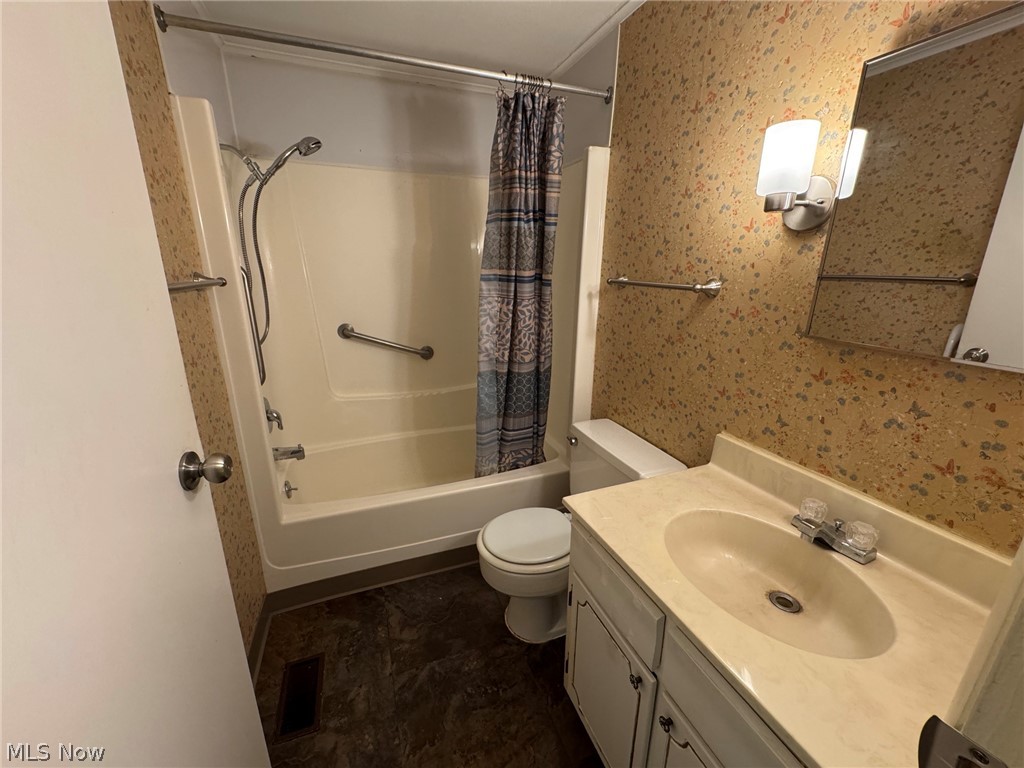 7294 Fox Mill Road, Unit 19D Mentor, OH 44060 - Photo 20 of 27 Bathroom featuring a single vanity with an integrated sink, an overhead wall sconce, and a tub/shower combination with grab bars