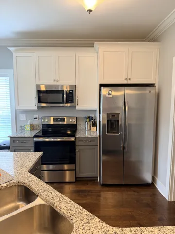 a kitchen with granite countertop a refrigerator and a sink