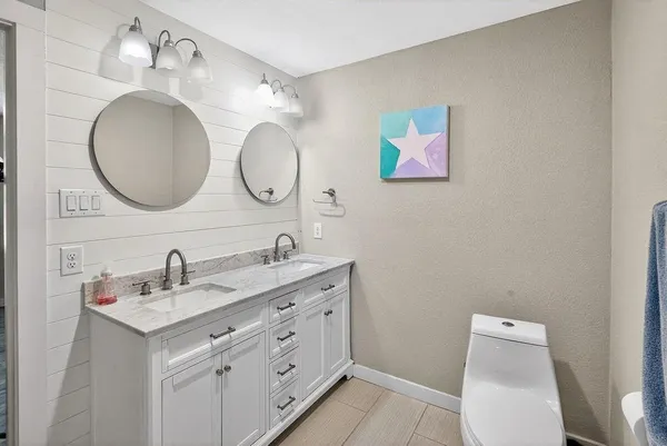 a bathroom with a double vanity sink and a mirror