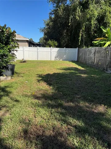 a view of a swimming pool with a big yard and large trees