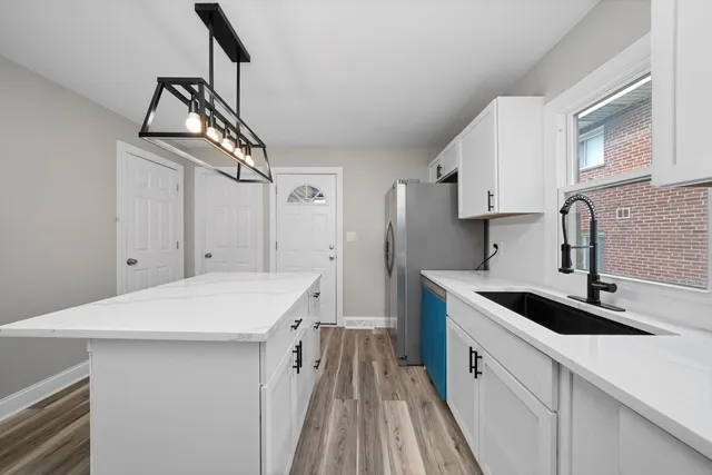 a kitchen that has a sink a stove and a wooden floors