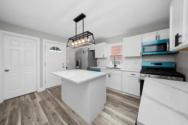 a kitchen with stainless steel appliances a sink stove and refrigerator