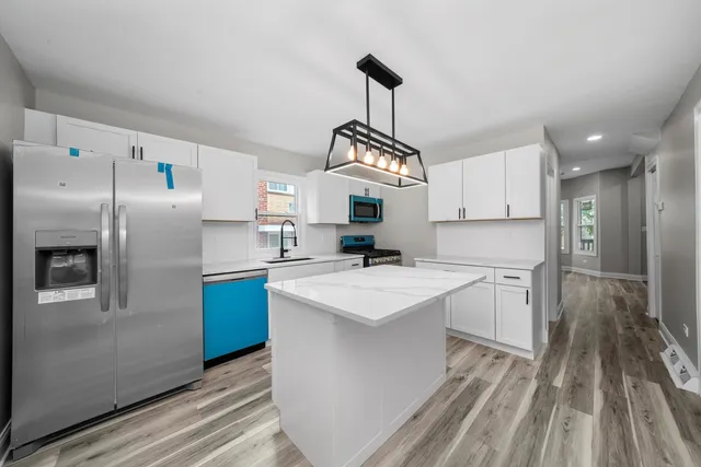 a kitchen with refrigerator cabinets and wooden floor