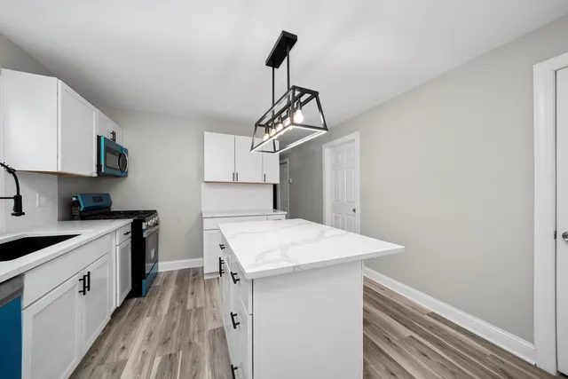 a kitchen that has a sink a stove and a wooden floor