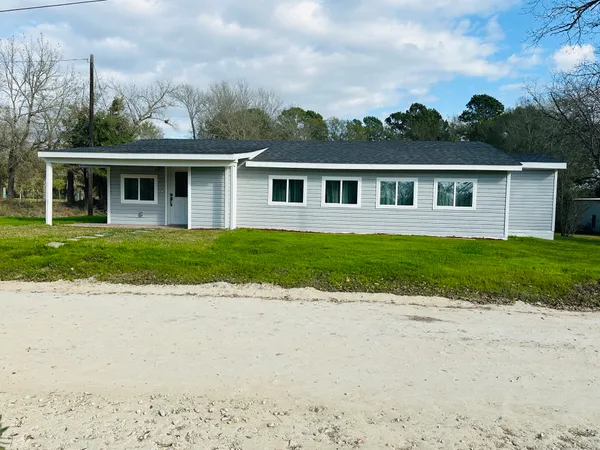 a front view of a house with a garden and yard