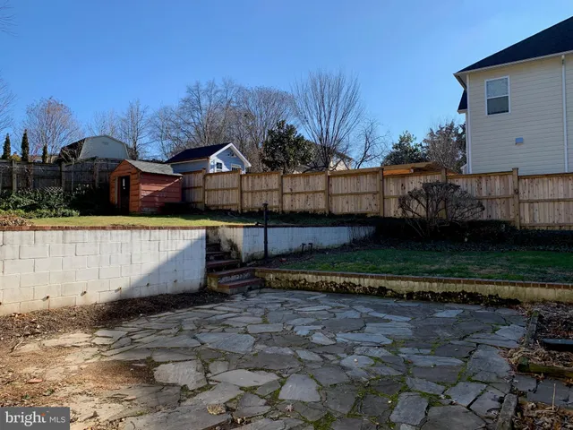 a view of a house with a yard and a large tree