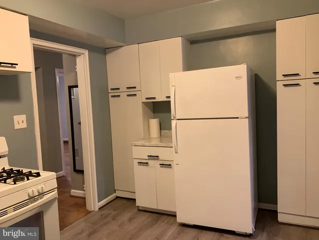 a white refrigerator freezer and a wooden floor