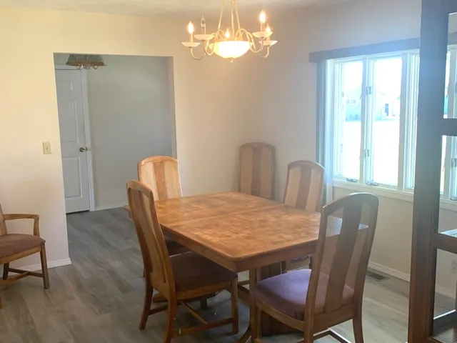 a dining room with furniture a chandelier and window