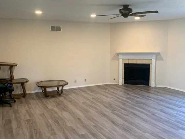 an empty room with wooden floor a fireplace
