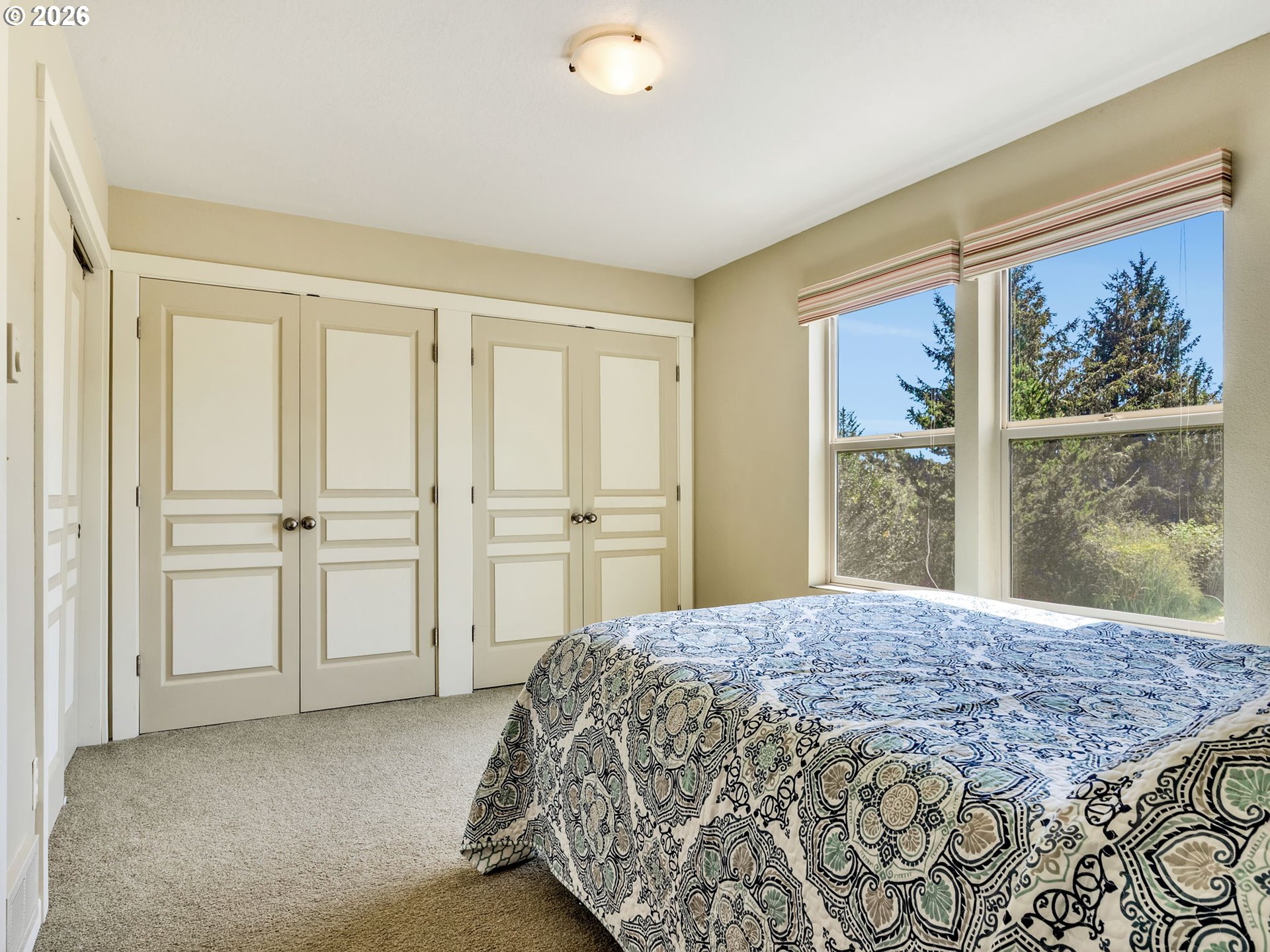 1077 Southwest Ridge Road Warrenton, OR 97146 - Photo 35 of 46 a bedroom with a large bed and a window