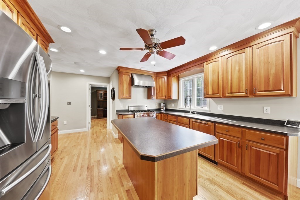 104 Forest Street Middleton, MA 01949 - Photo 9 of 41 a kitchen with wooden cabinets a sink dishwasher a stove and a refrigerator with wooden floor