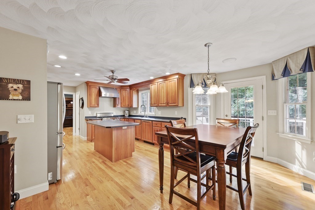 104 Forest Street Middleton, MA 01949 - Photo 10 of 41 a dining hall with stainless steel appliances kitchen island granite countertop wooden floor a dining table and chairs