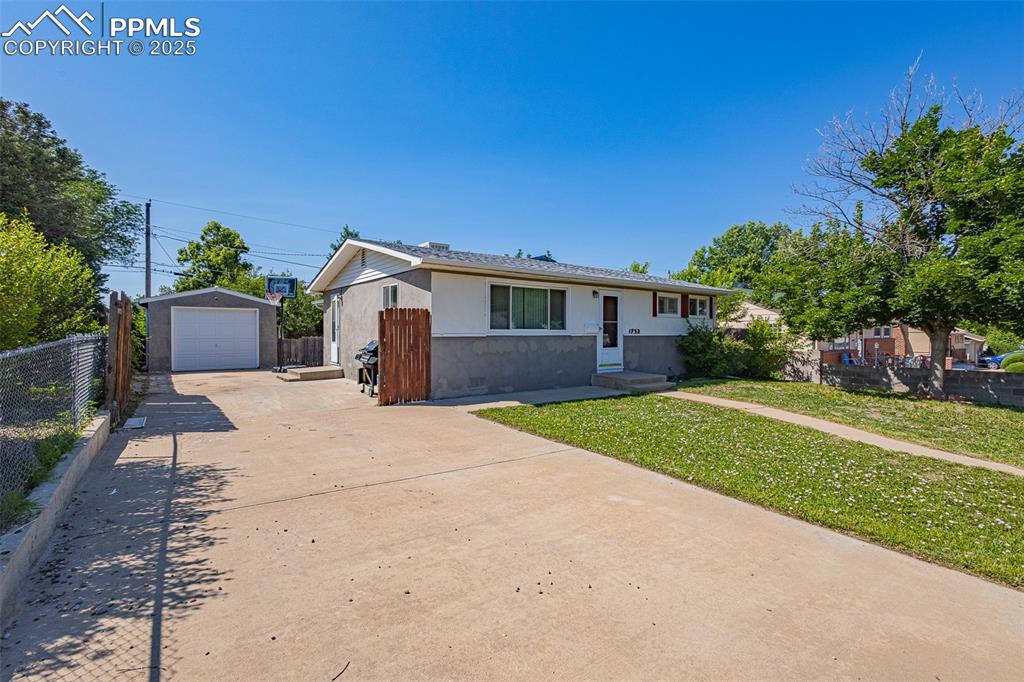 1732 Comanche Road Pueblo, CO 81001 - Photo 2 of 24 a front view of a house with a yard and a garage