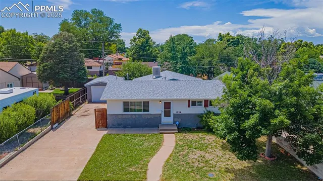 a aerial view of a house with a yard table and chairs