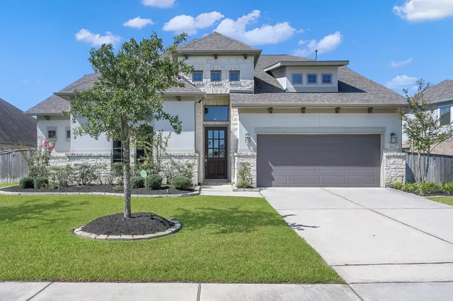 a front view of a house with a yard and garage