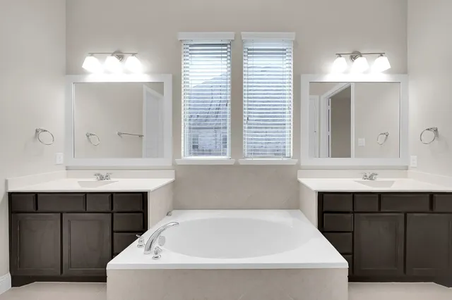 a bathroom with a bathtub sink and mirror