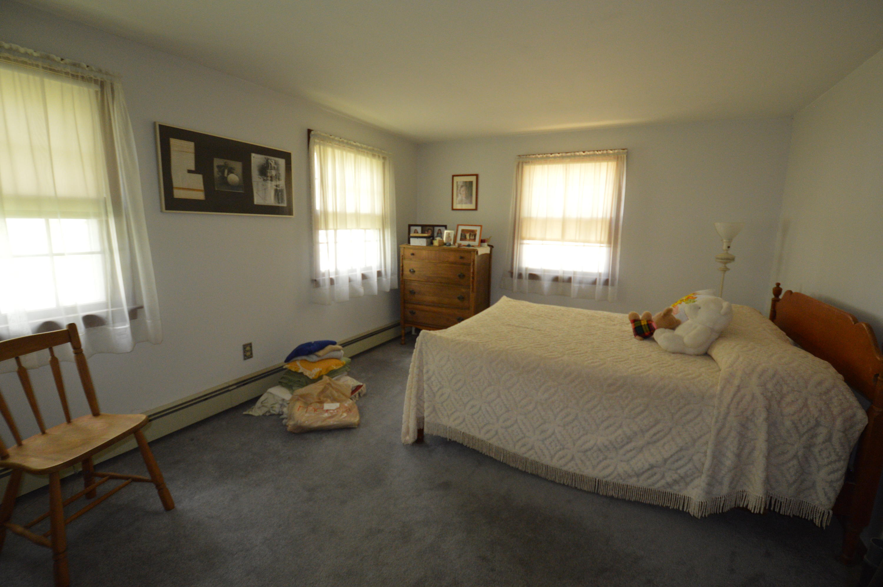 70 Geraldine Road Cotuit, MA 02635 - Photo 8 of 10 a bedroom with a bed a couch and windows