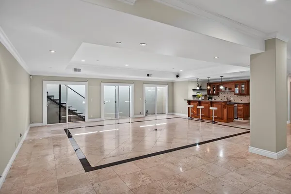 a room with stainless steel appliances kitchen island granite countertop a refrigerator and cabinets