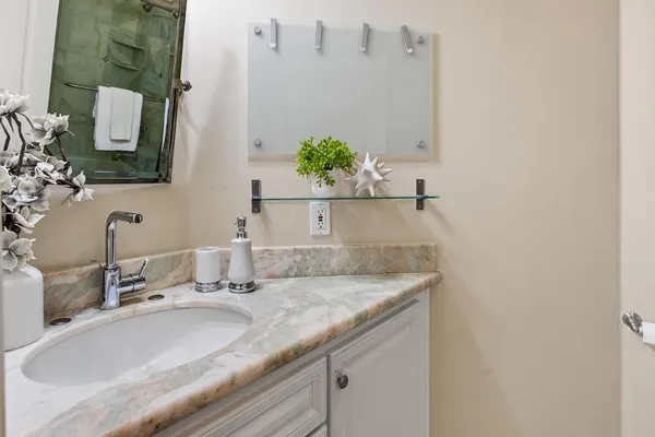 a bathroom with a toilet sink mirror and vanity