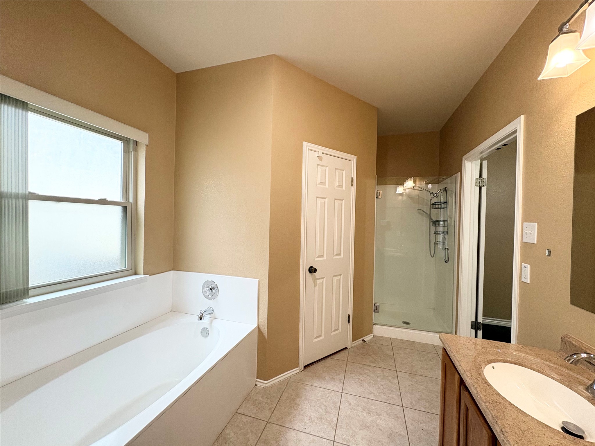 8103 Ephraim Road Austin, TX 78717 - Photo 31 of 35 Relax in a soaking tub with privacy glass, complemented by a modern vanity and separate shower.