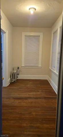 a view of a room with wooden floor and white walls