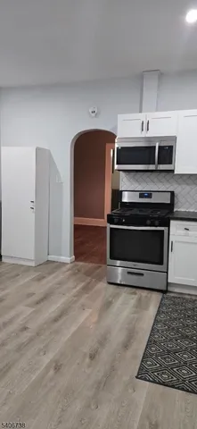 a view of kitchen with stainless steel appliances granite countertop a stove and a refrigerator