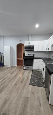 a kitchen with kitchen island granite countertop a stove and a sink