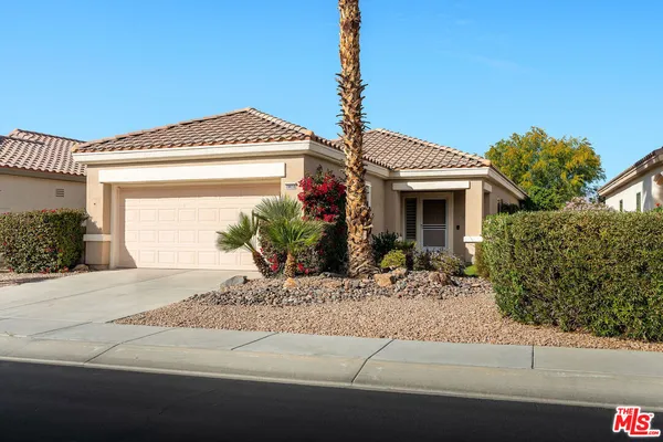 a front view of a house with garage and plants