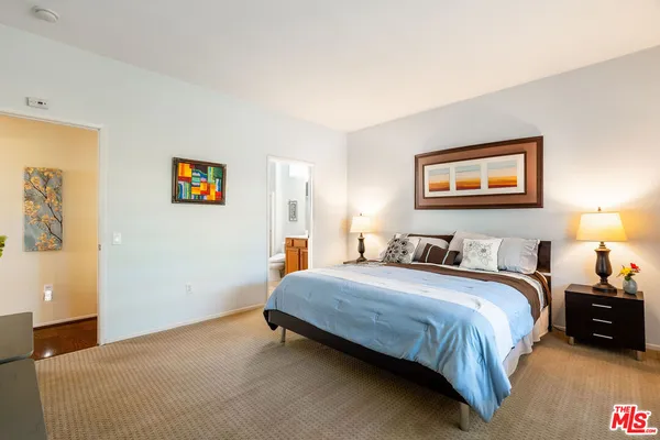 a bedroom with a bed and painting on the wall