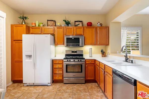 a kitchen with stainless steel appliances a stove a sink and a refrigerator