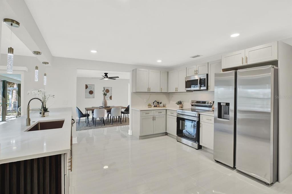4346 Marine Parkway New Port Richey, FL 34652 - Photo 21 of 61 a kitchen with white cabinets and stainless steel appliances
