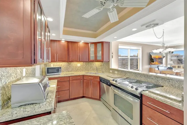 a kitchen with stainless steel appliances granite countertop a sink stove and cabinets