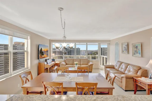 a living room with furniture large window and a table