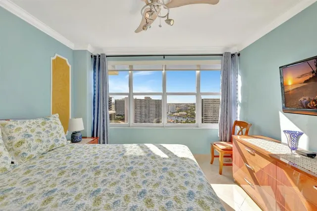 a bedroom with a bed and large windows