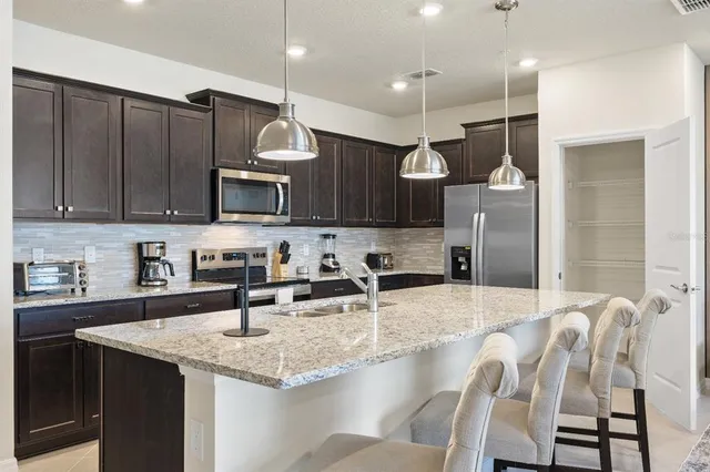 a kitchen with granite countertop a sink stainless steel appliances and cabinets