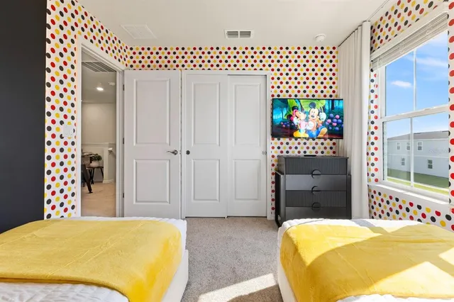 a bedroom with two bed and lamps