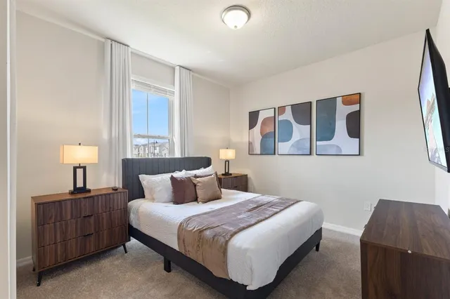 a bedroom with a bed and a painting on the wall