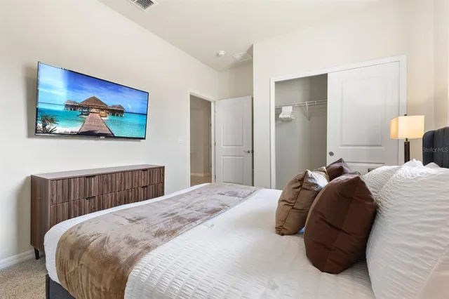 a bedroom with a bed and painting on the wall