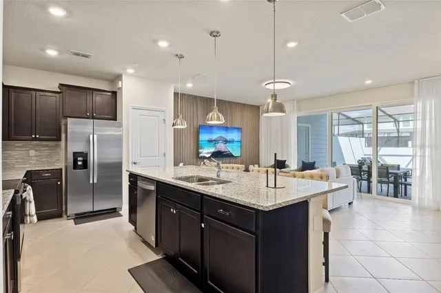 a open kitchen with kitchen island a sink dishwasher a dining table and chairs with wooden floor