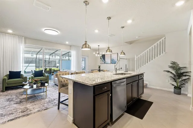 a kitchen with stainless steel appliances a dining table chairs sink and microwave