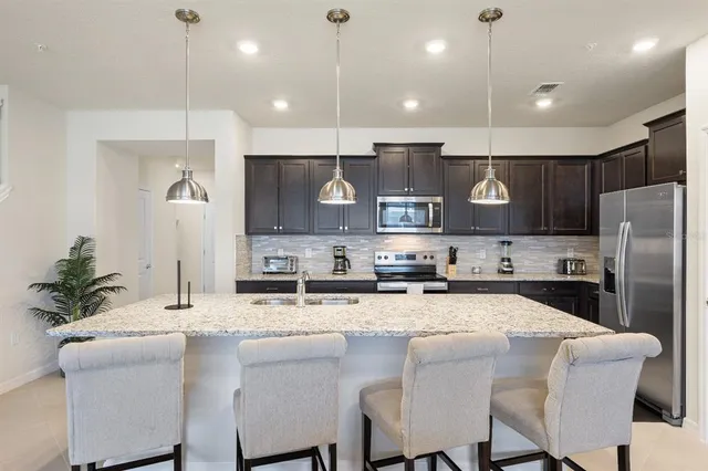 a kitchen with granite countertop a sink cabinets and stainless steel appliances