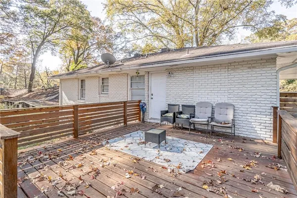 a backyard of a house with a large tree and wooden fence