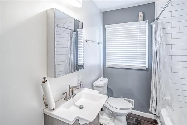 a bathroom with a toilet a sink and a mirror