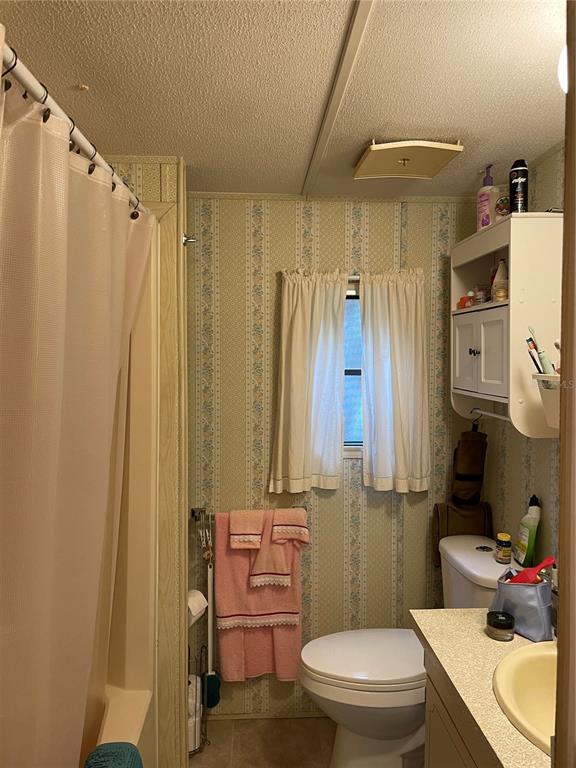251 Patterson Road, Unit C25 Haines City, FL 33844 - Photo 7 of 10 a bathroom with a sink a toilet and shower curtain