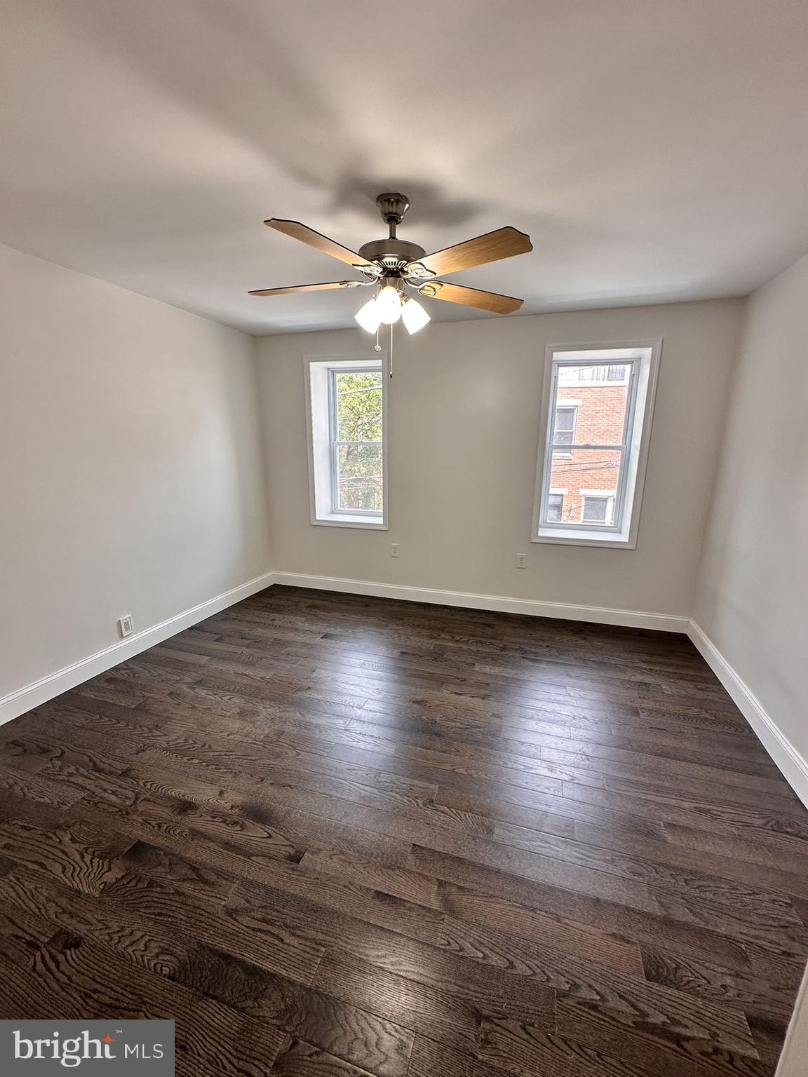540 Manton Street Philadelphia, PA 19147 - Photo 12 of 25 an empty room with wooden floor chandelier fan and windows