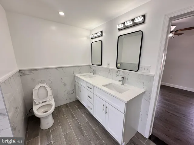 an empty room with wooden floor chandelier fan and windows